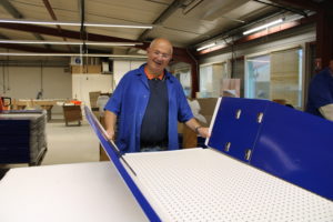Un homme plie un présentoir de venter en carton à l'ESAT des Ateliers du Breuil
