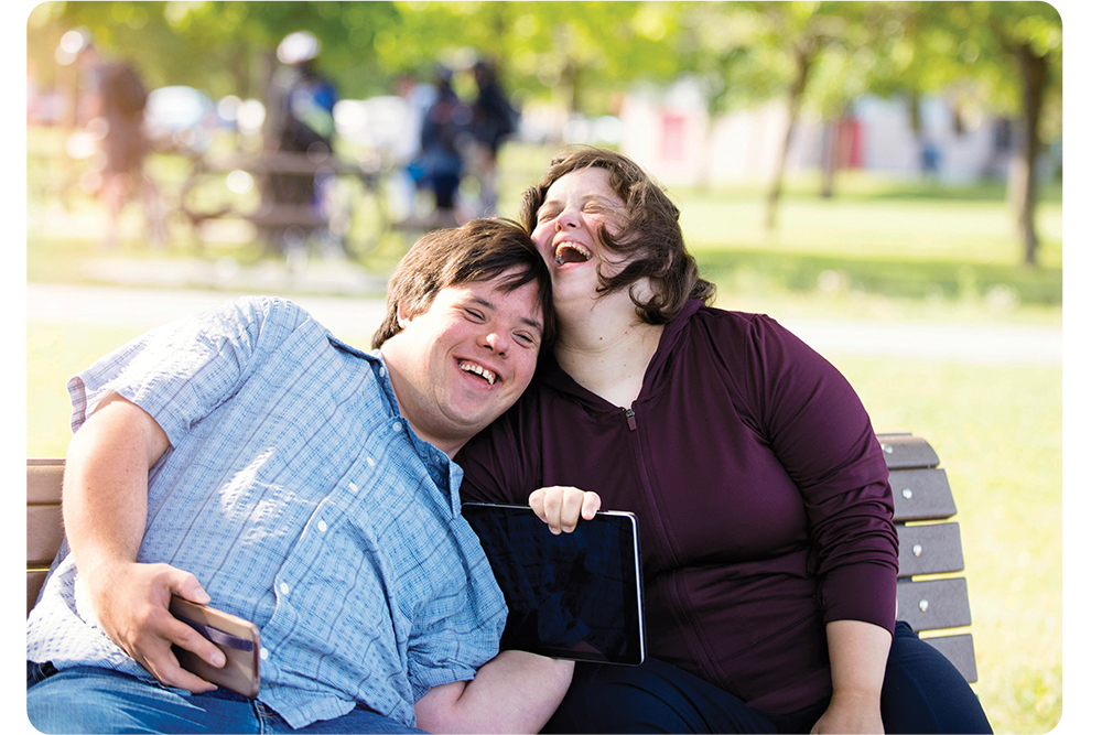 un couple assis sur un banc public rie